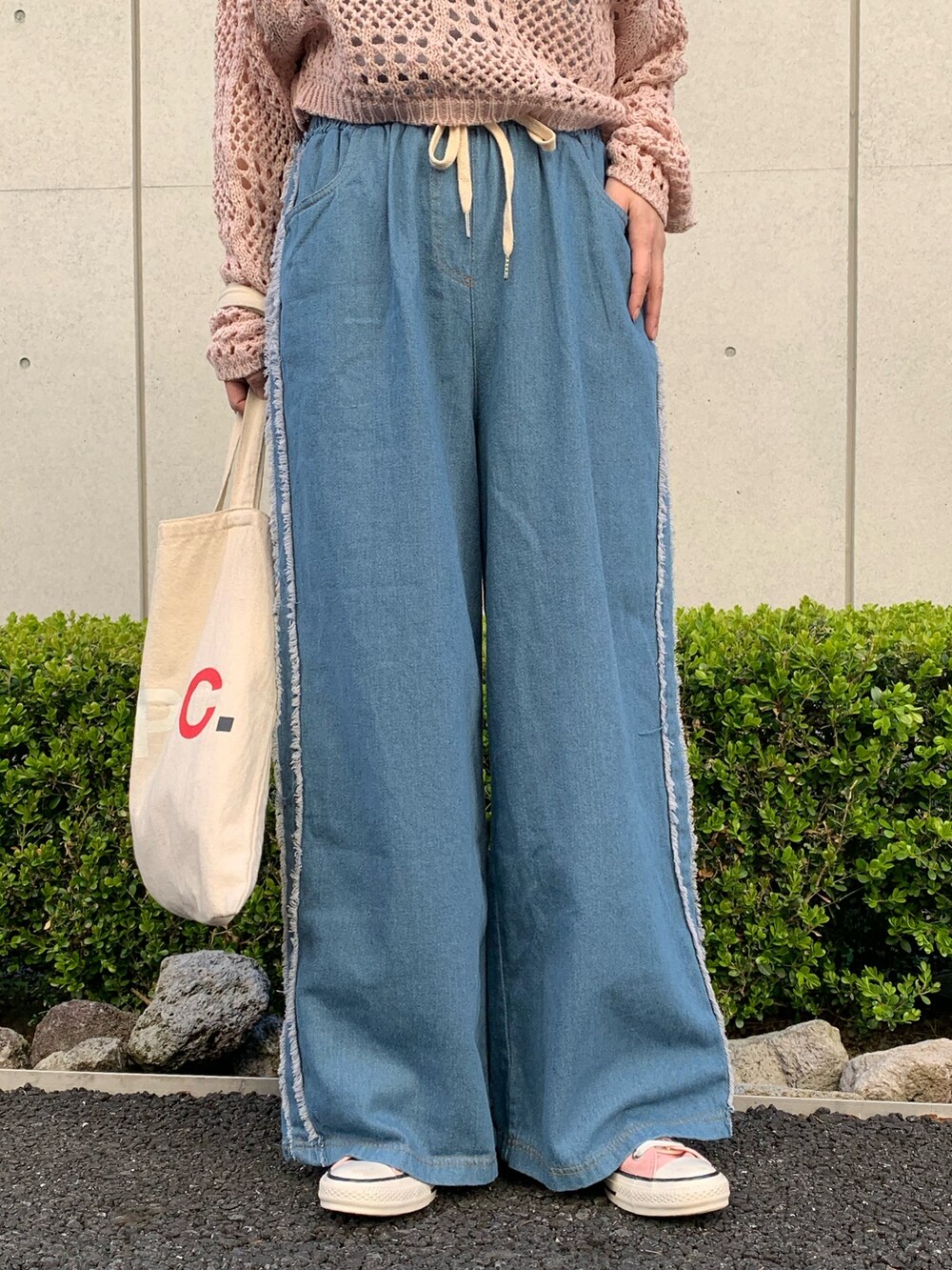 ピンク系のTシャツ/カットソー、ブルー系のデニムパンツ、ホワイト系のバッグを着用したレディースの春コーディネートの5枚目の写真