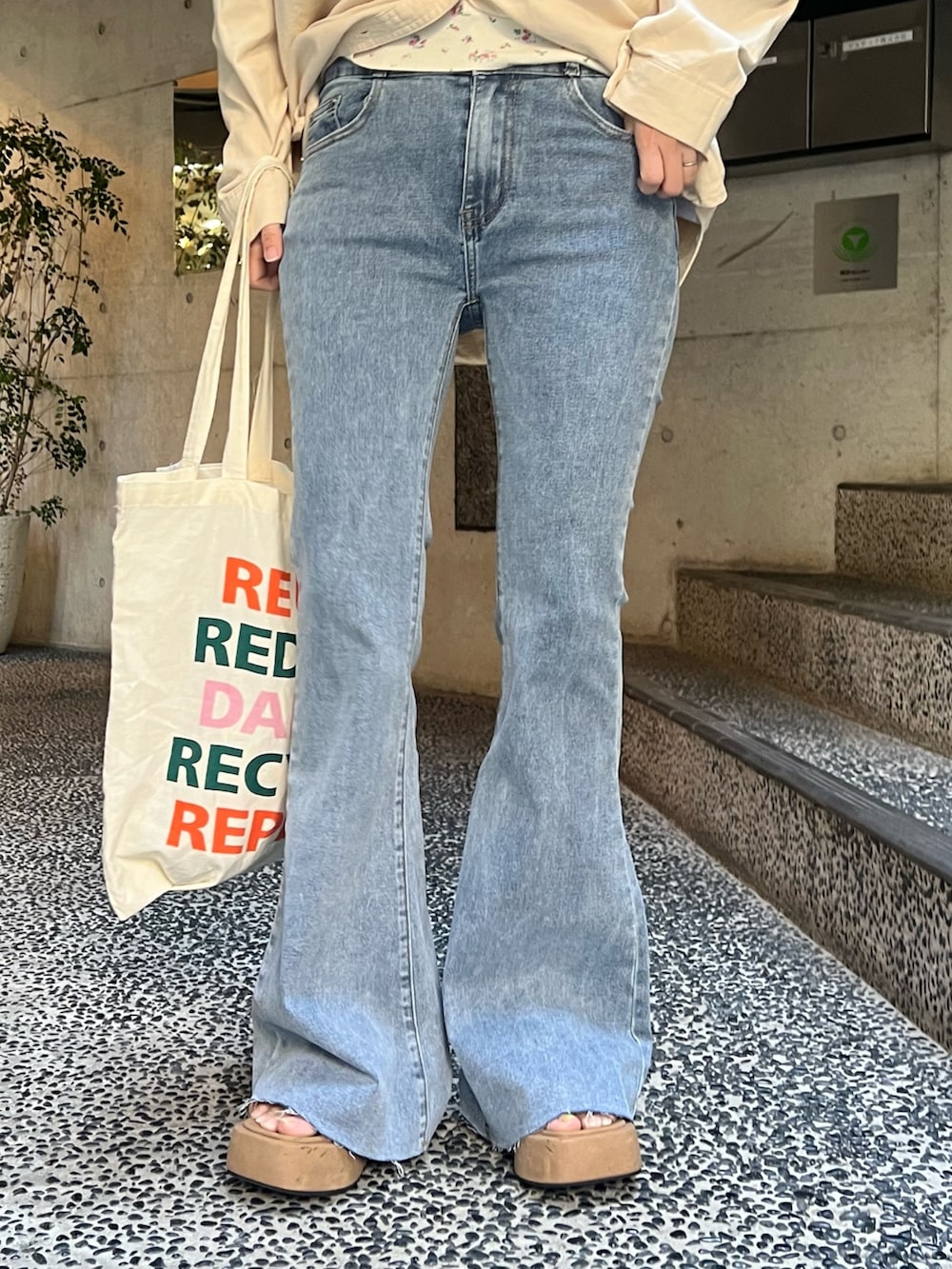 ベージュ系のシャツ/ブラウス、ホワイト系のTシャツ/カットソー、ブルー系のデニムパンツを着用したレディースの春コーディネートの4枚目の写真