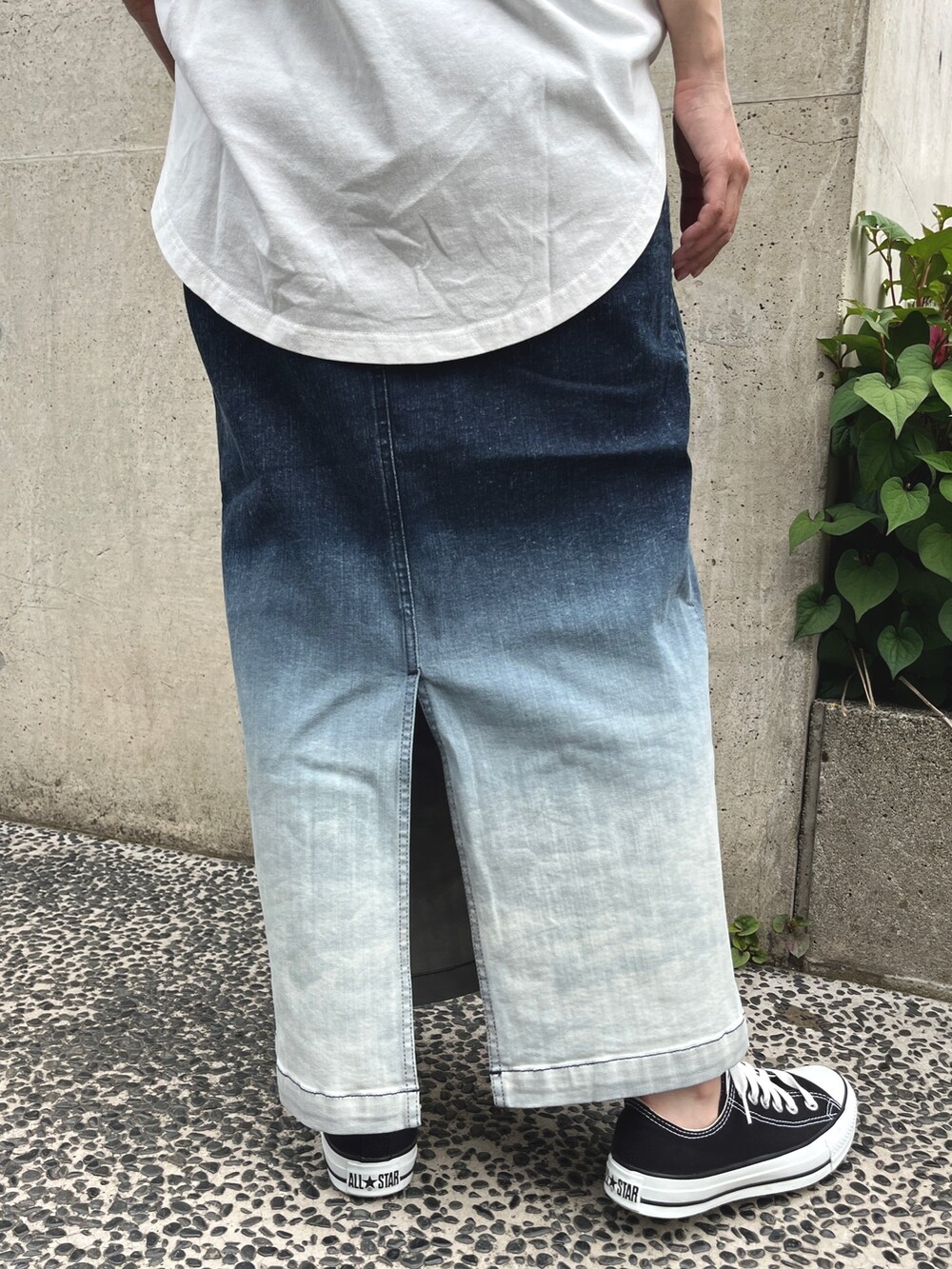 ホワイト系のTシャツ/カットソー、ブルー系のスカート、ブラック系のスニーカーを着用したレディースの春コーディネートの6枚目の写真