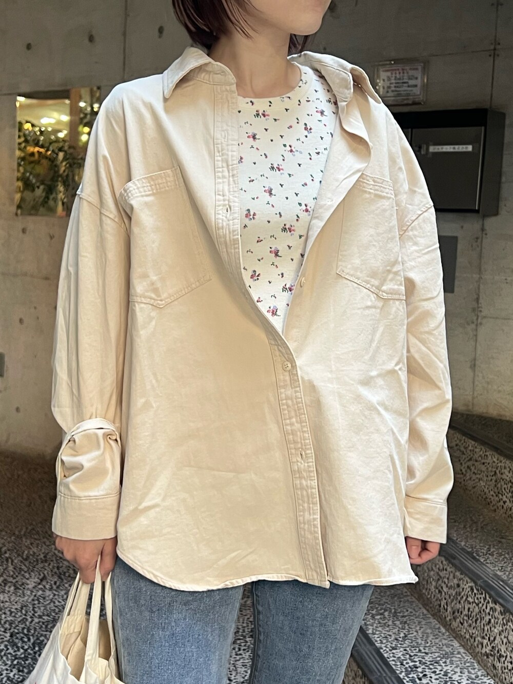 ベージュ系のシャツ/ブラウス、ホワイト系のTシャツ/カットソー、ブルー系のデニムパンツを着用したレディースの春コーディネートの3枚目の写真