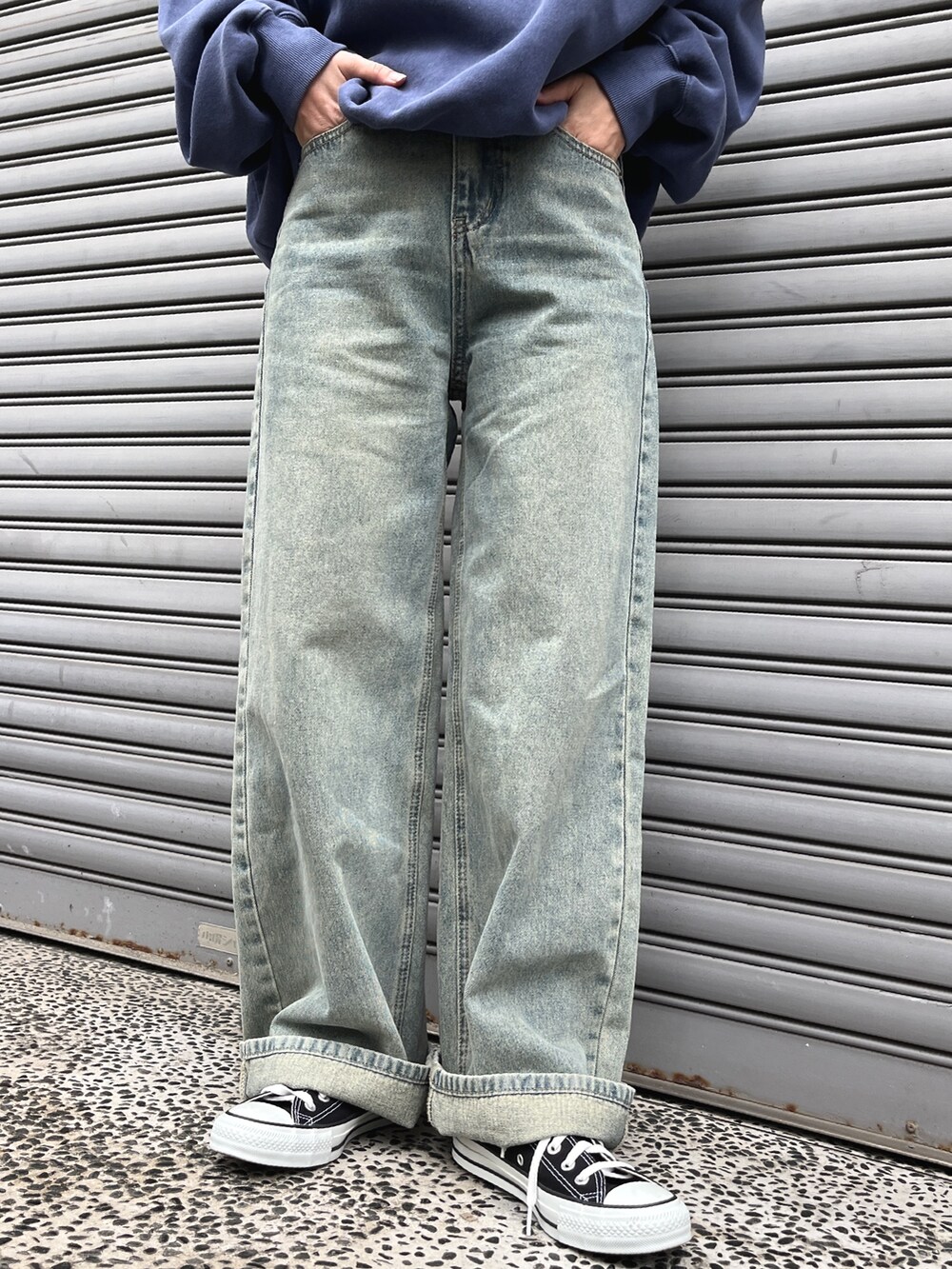 ブルー系のデニムパンツ、ブラウン系のトートバッグ、ブラック系のスニーカーを着用したレディースの冬コーディネートの3枚目の写真