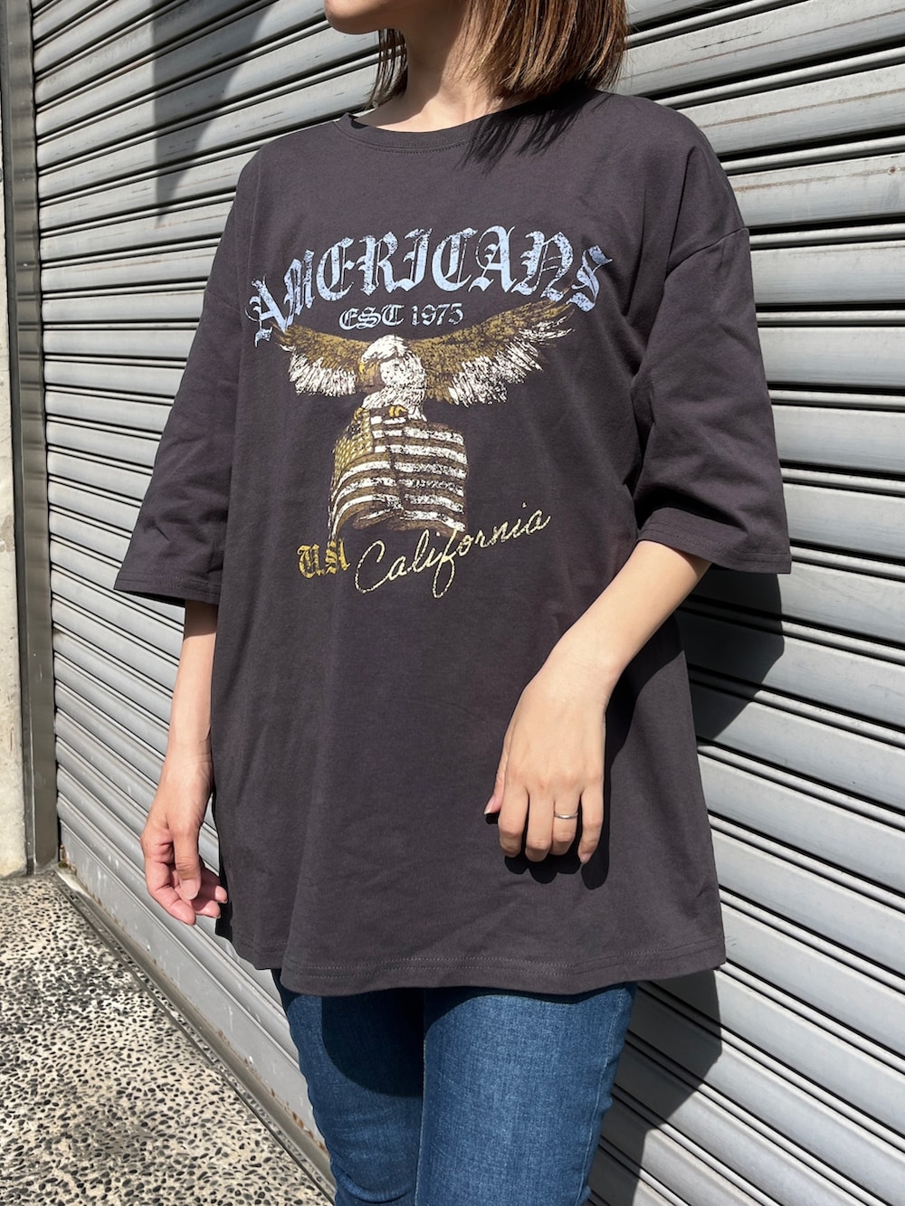 ブルー系のデニムパンツ、グレー系のTシャツ/カットソー、イエロー系のスニーカーを着用したレディースの春コーディネートの2枚目の写真