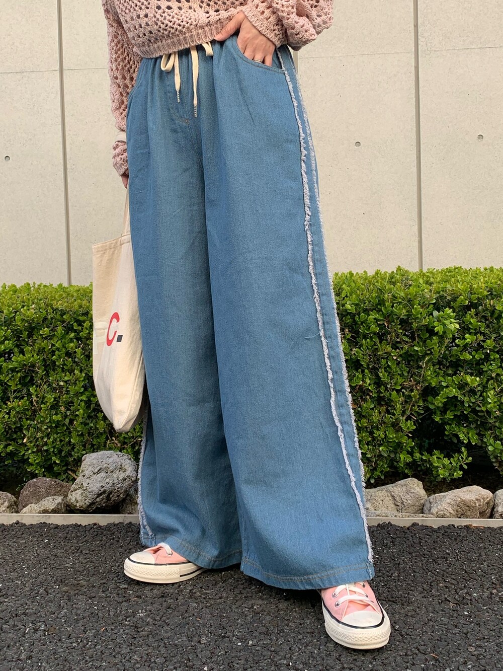 ピンク系のTシャツ/カットソー、ブルー系のデニムパンツ、ホワイト系のバッグを着用したレディースの春コーディネートの6枚目の写真