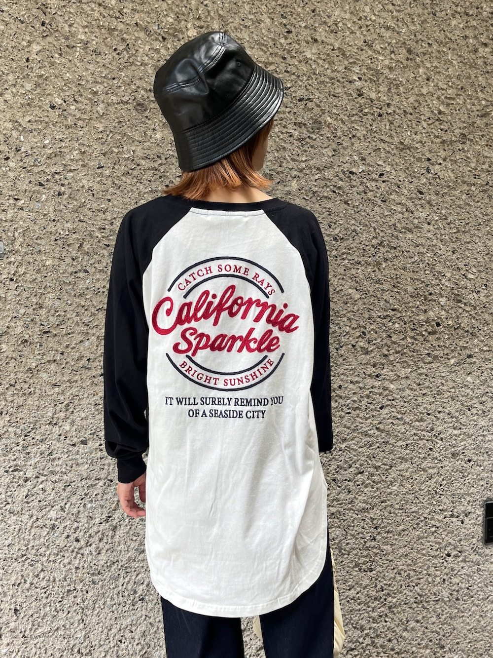 ホワイト系のスニーカー、ホワイト系のショルダーバッグ、ブルー系のデニムパンツを着用したレディースの秋コーディネートの4枚目の写真