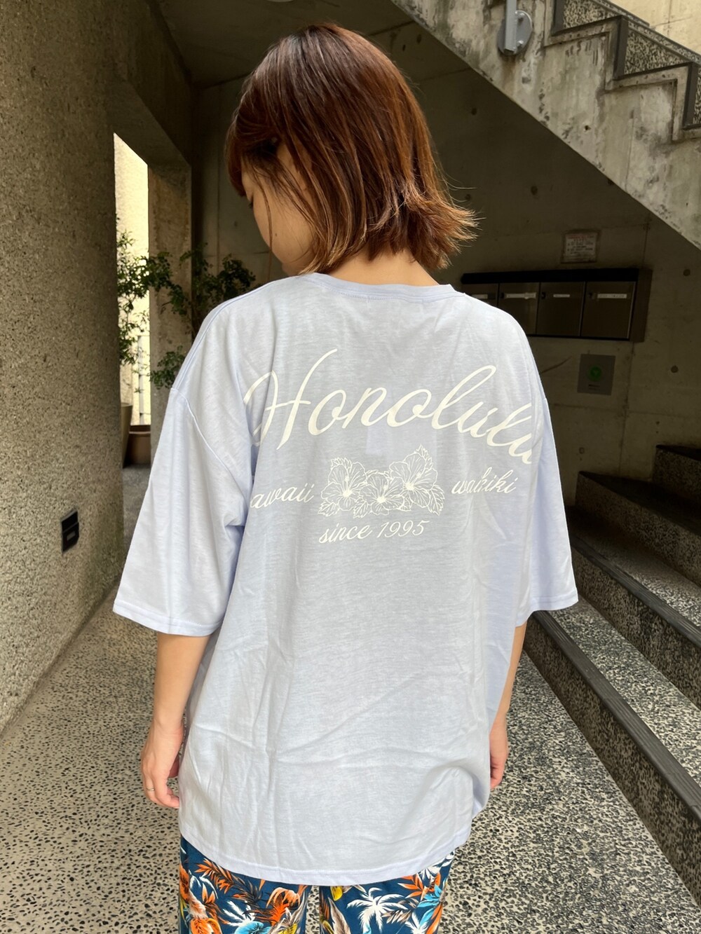 ブルー系のTシャツ/カットソー、ブラック系のスニーカー、ベージュ系のトートバッグを着用したレディースの春コーディネートの3枚目の写真