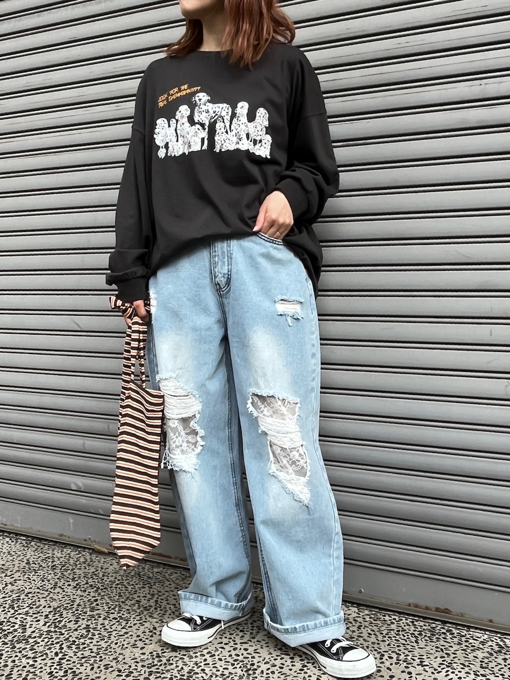 ブラック系のTシャツ/カットソー、ブラウン系のトートバッグ、ブラック系のスニーカーを着用したレディースの夏コーディネートの2枚目の写真