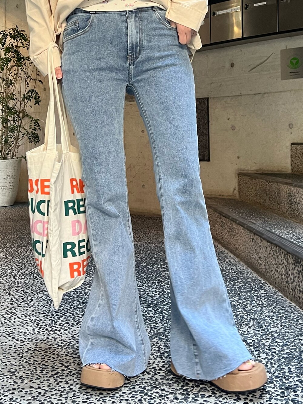 ベージュ系のシャツ/ブラウス、ホワイト系のTシャツ/カットソー、ブルー系のデニムパンツを着用したレディースの春コーディネートの6枚目の写真