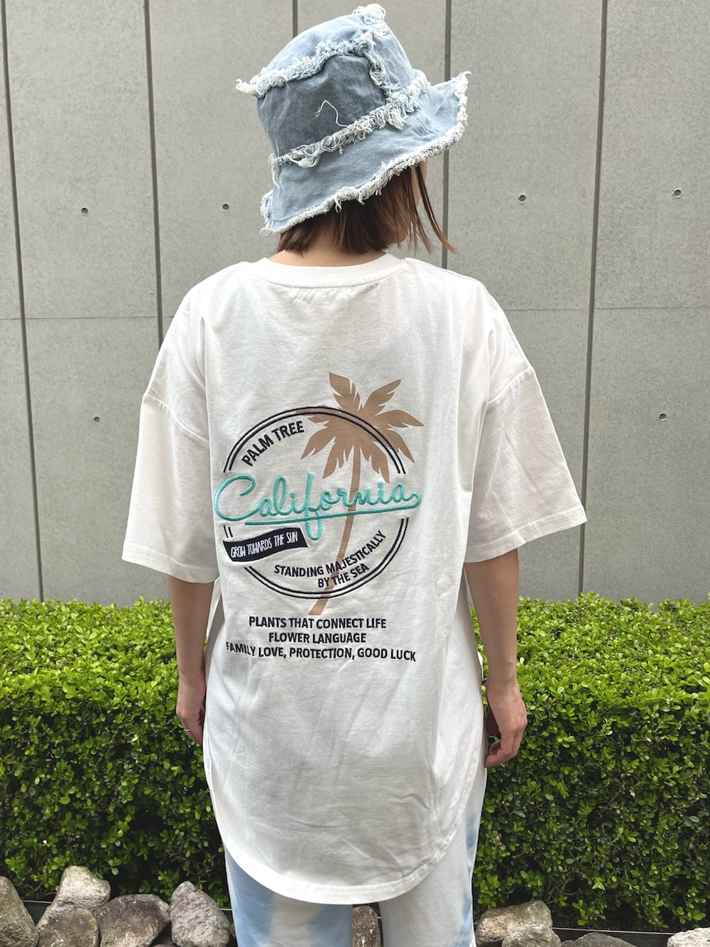 ホワイト系のTシャツ/カットソー、ホワイト系のスニーカー、ブルー系のハットを着用したレディースの春コーディネートの6枚目の写真
