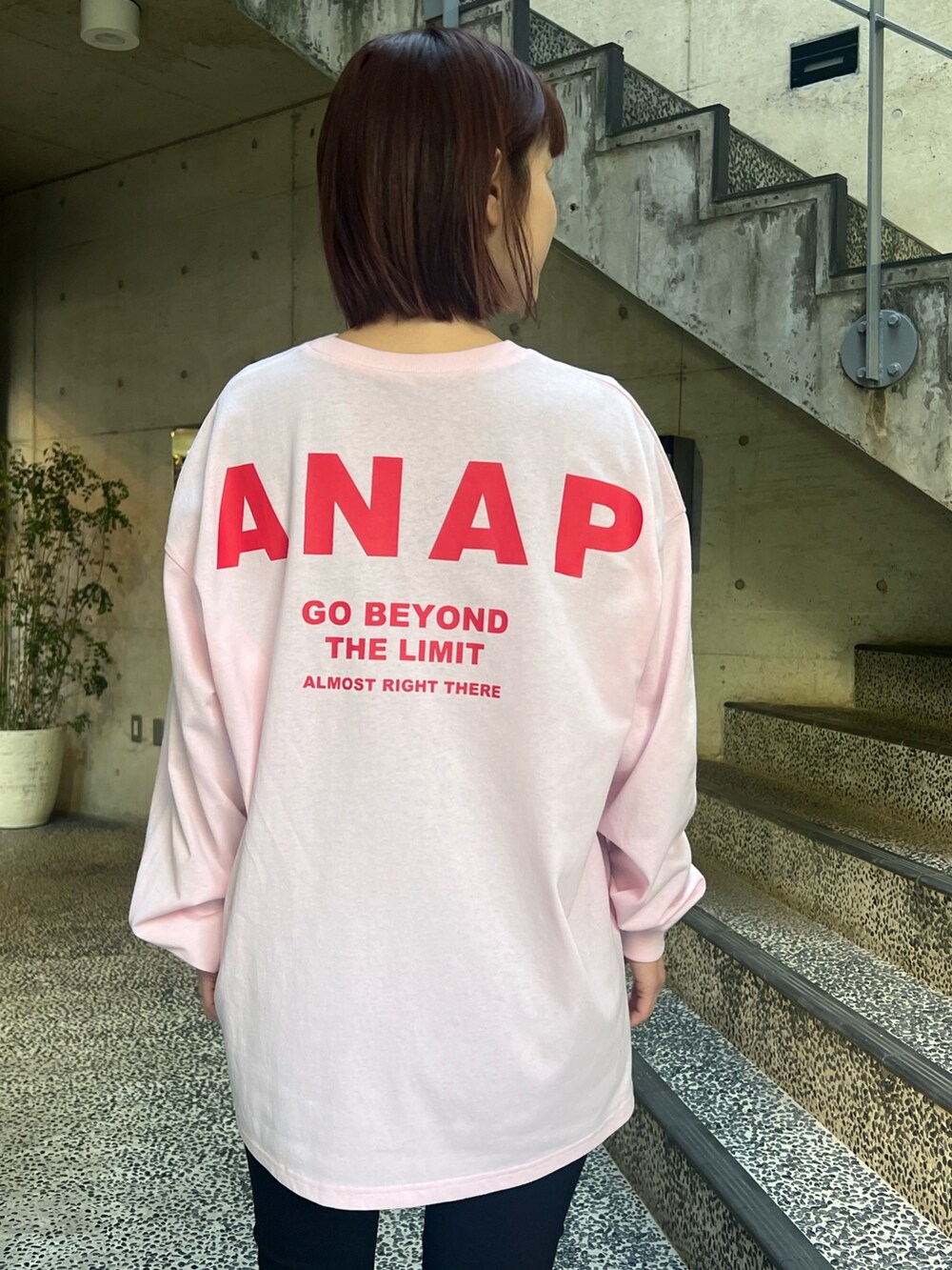 ピンク系のTシャツ/カットソー、ホワイト系のショルダーバッグ、ブラック系のレギンス/スパッツを着用したレディースの春コーディネートの3枚目の写真