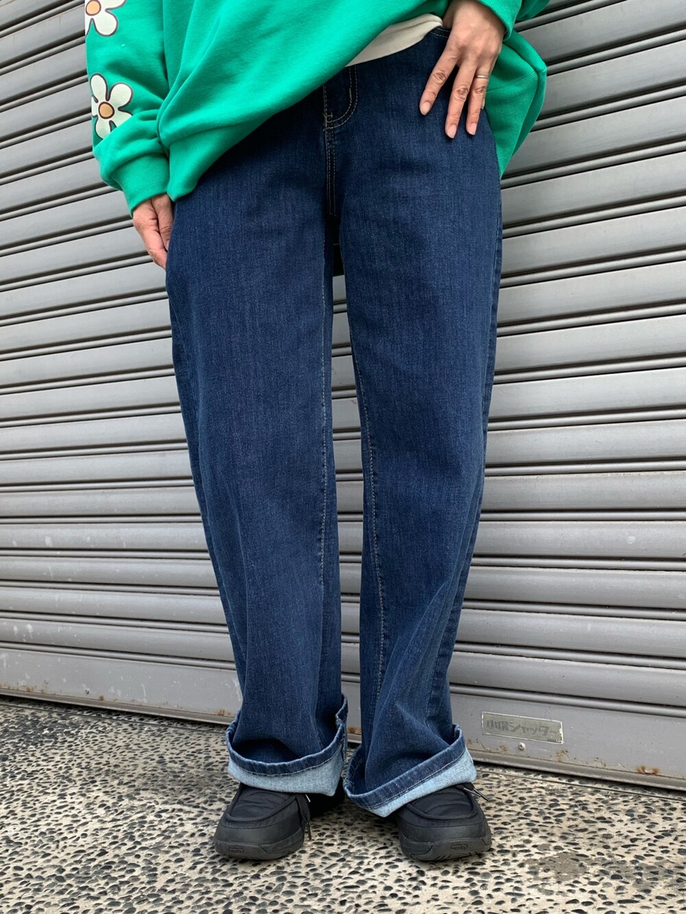 グリーン系のスウェット、ブルー系のデニムパンツ、ブラック系のシューズを着用したレディースの冬コーディネートの6枚目の写真