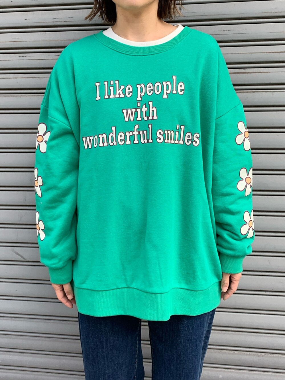 グリーン系のスウェット、ブルー系のデニムパンツ、ブラック系のシューズを着用したレディースの冬コーディネートの4枚目の写真