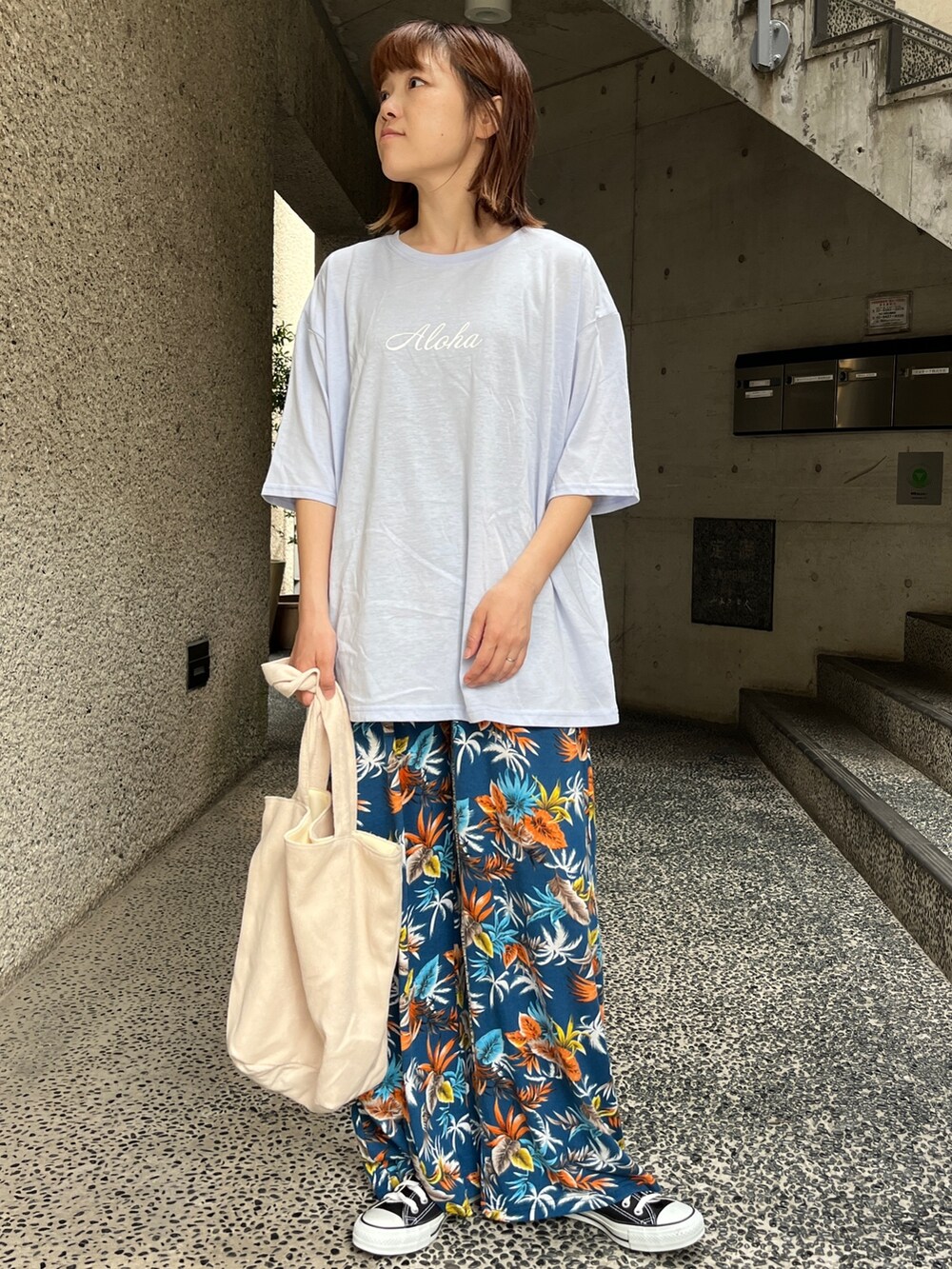 ブルー系のTシャツ/カットソー、ブラック系のスニーカー、ベージュ系のトートバッグを着用したレディースの春コーディネートの2枚目の写真