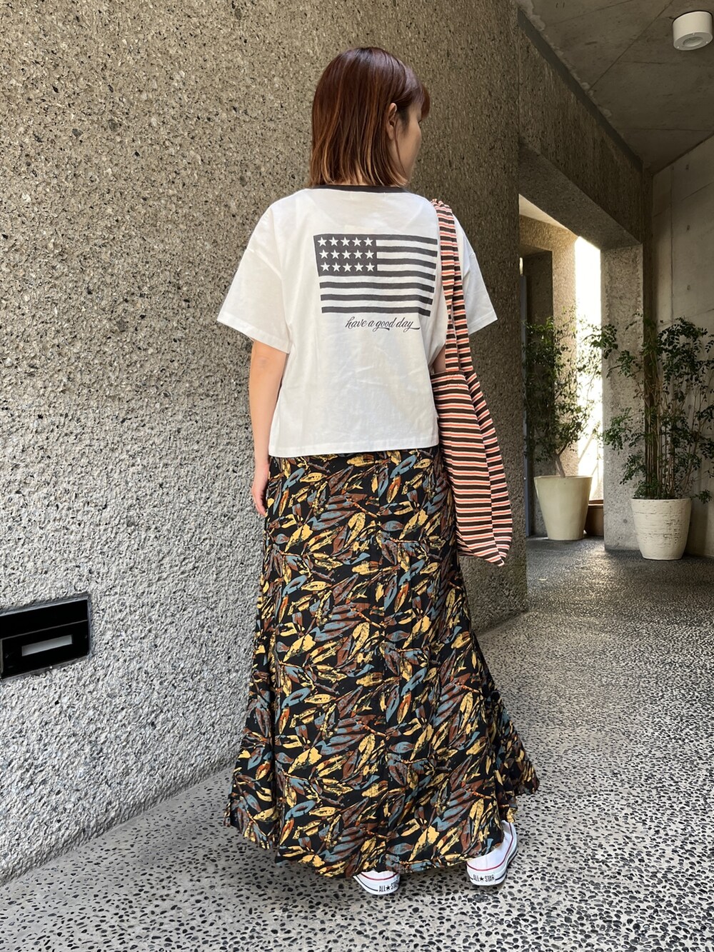 ホワイト系のTシャツ/カットソー、グレー系のスカート、ホワイト系のスニーカーを着用したレディースの春コーディネートの3枚目の写真