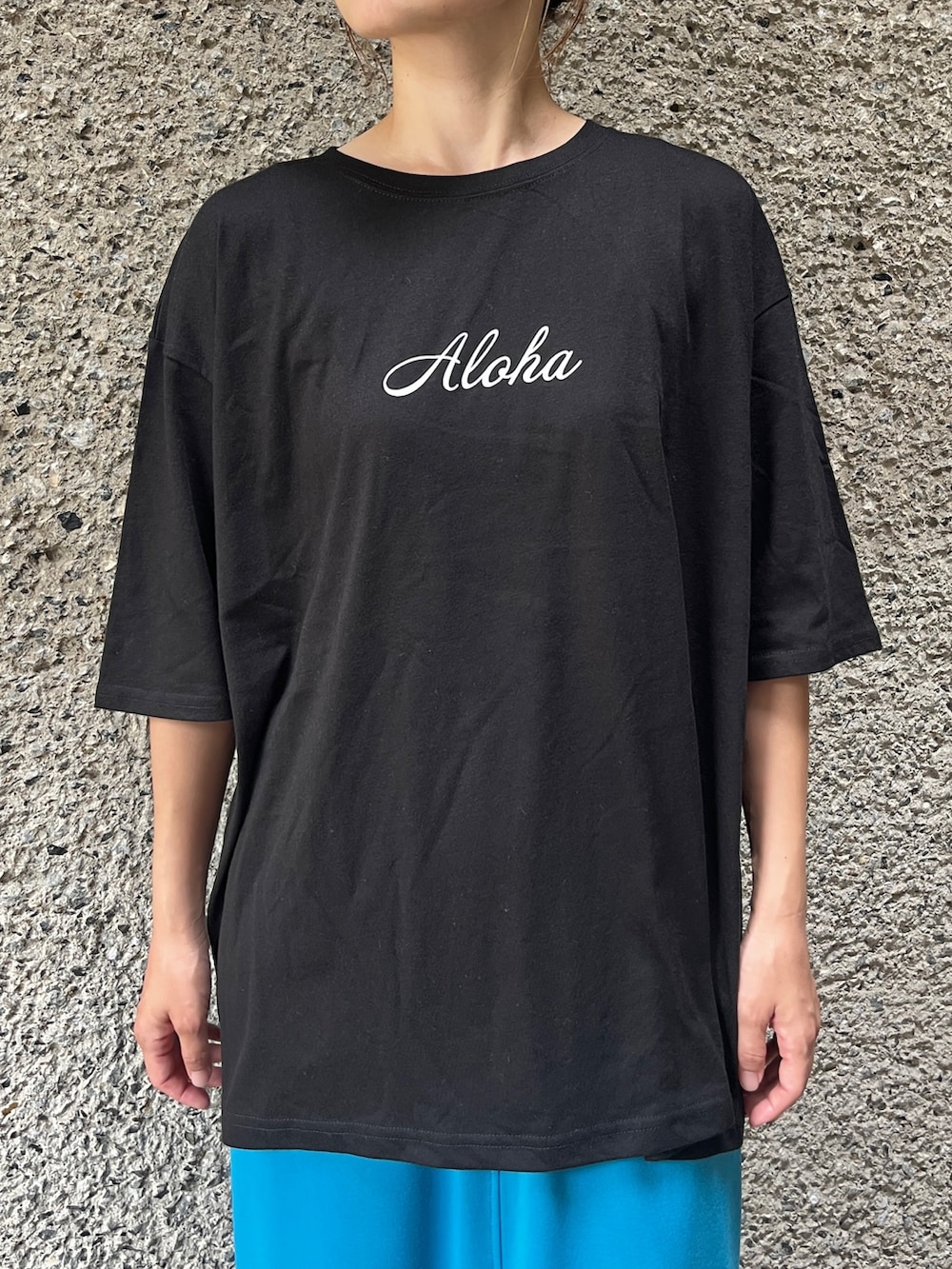 ブラック系のTシャツ/カットソー、ブルー系のスカート、ブラック系のサンダルを着用したレディースの夏コーディネートの3枚目の写真