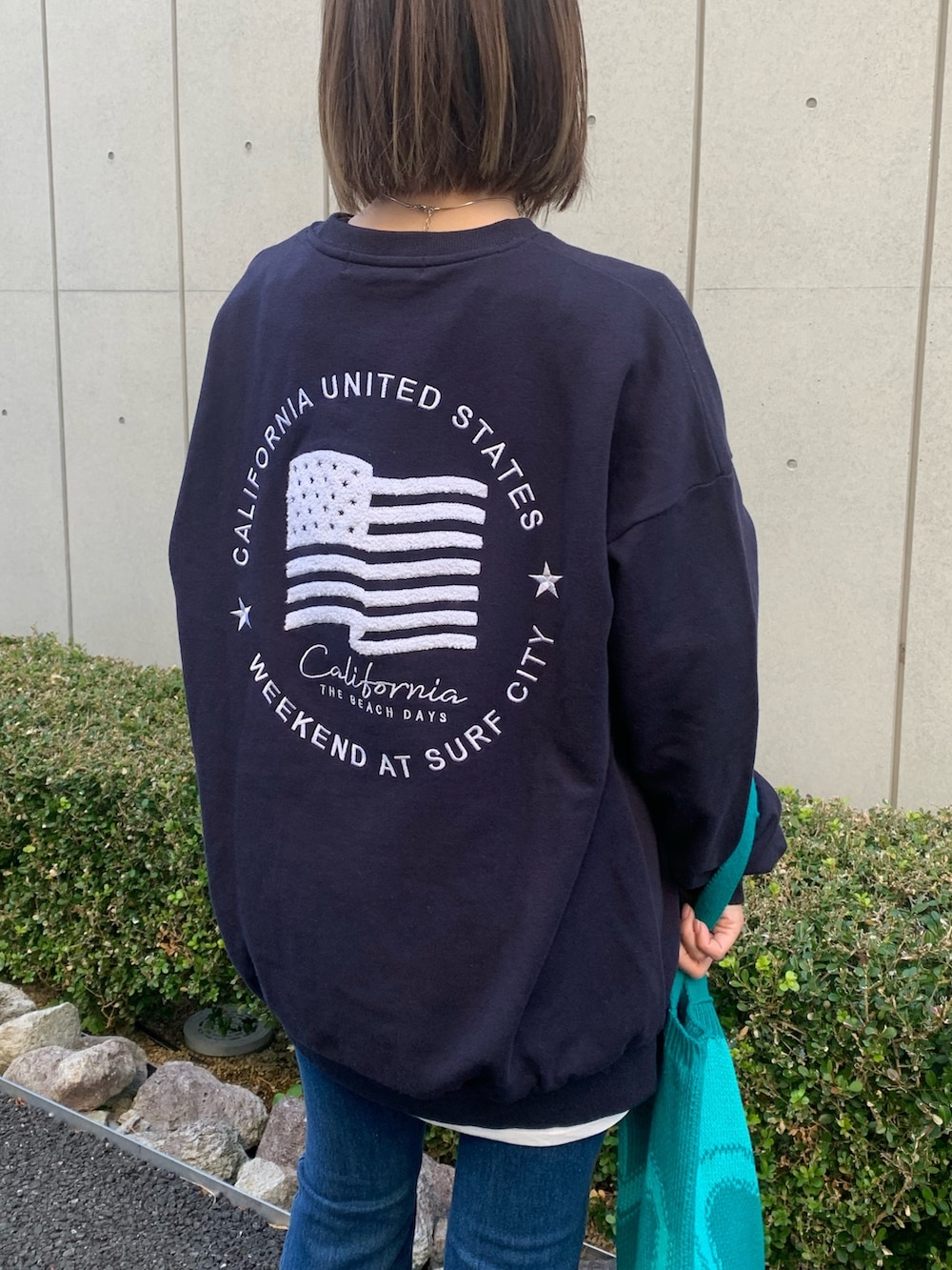 ブルー系のスウェット、ブルー系のトートバッグ、イエロー系のスニーカーを着用したレディースの冬コーディネートの3枚目の写真