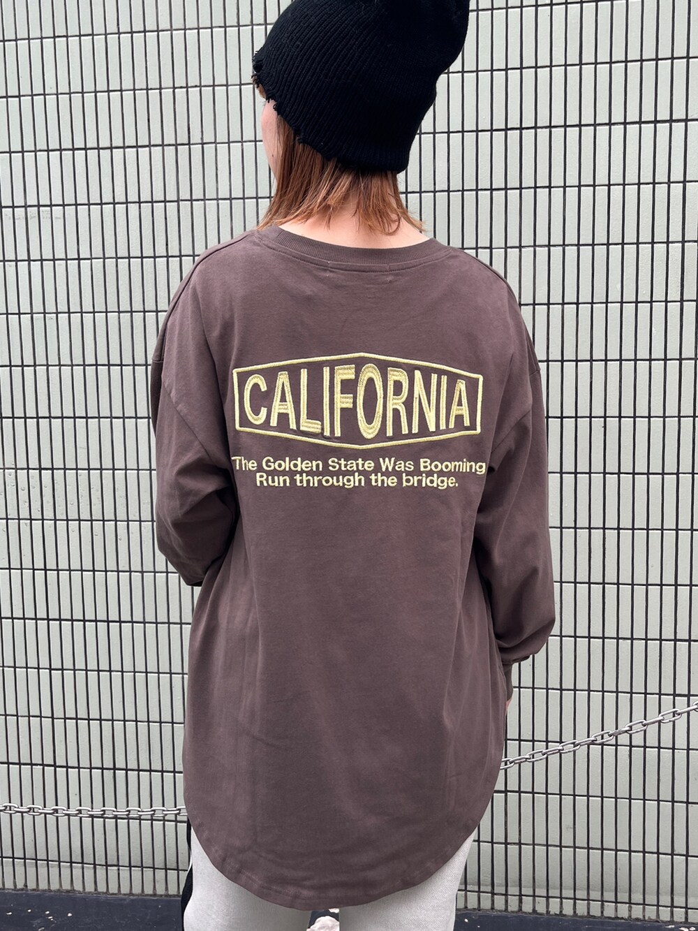 ブラウン系のTシャツ/カットソー、ホワイト系のその他パンツ、ブラック系のスニーカーを着用したレディースの秋コーディネートの3枚目の写真