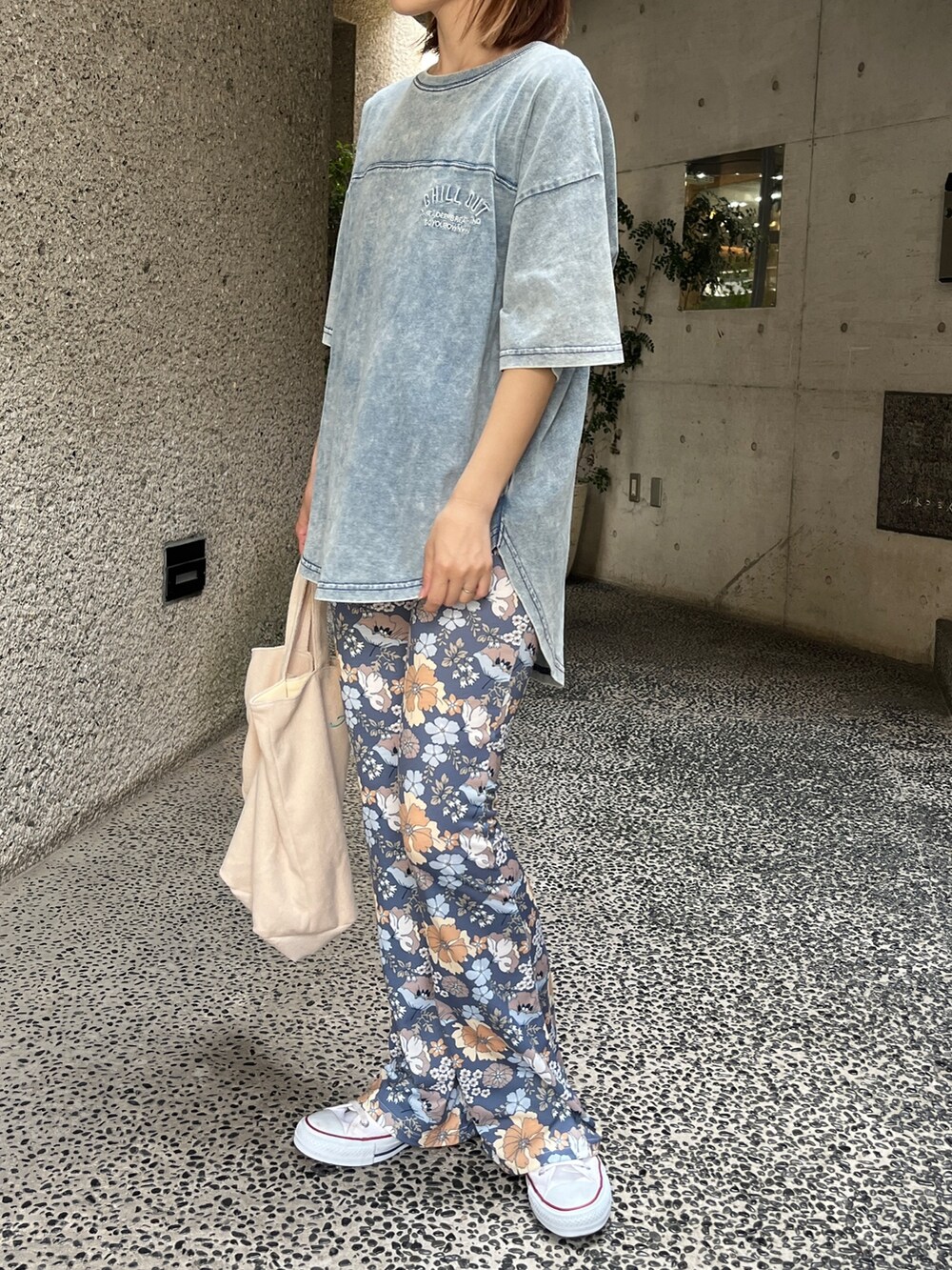 ホワイト系のスニーカー、ブルー系のTシャツ/カットソー、ベージュ系のトートバッグを着用したレディースの夏コーディネートの2枚目の写真