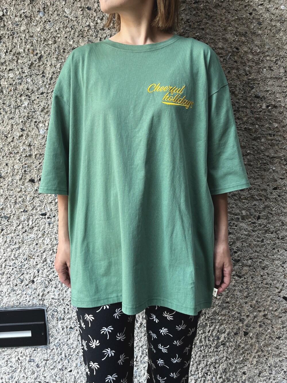 ブラック系のその他パンツ、グリーン系のTシャツ/カットソー、ブラック系のトートバッグを着用したレディースの夏コーディネートの2枚目の写真