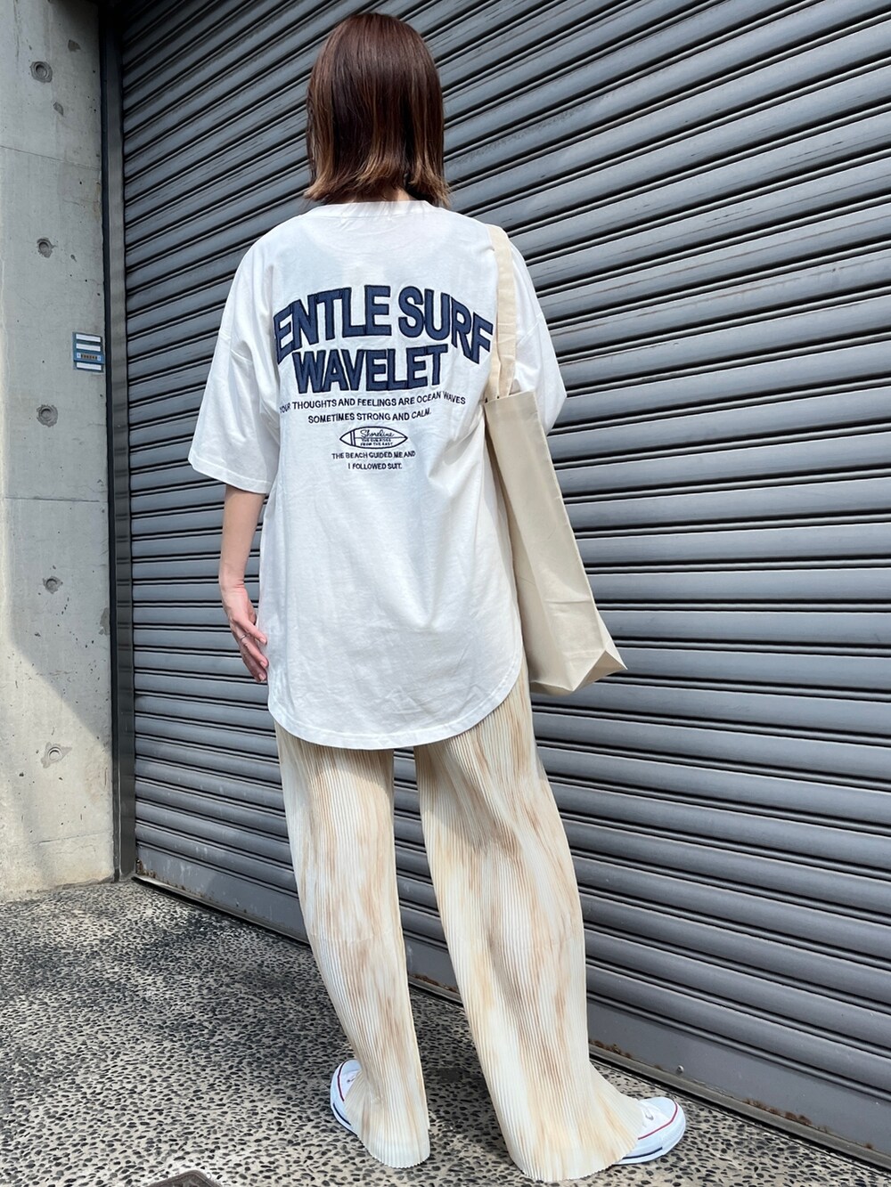 ホワイト系のTシャツ/カットソー、ベージュ系のパンツを着用したレディースの春コーディネートの2枚目の写真