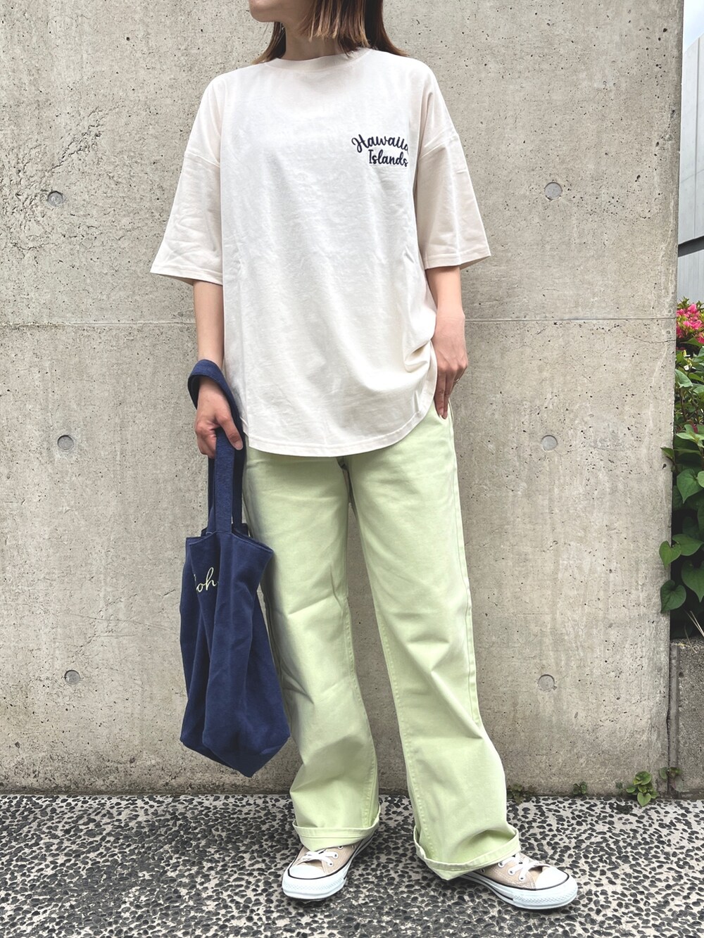 ベージュ系のスニーカー、グリーン系のデニムパンツ、ブルー系のトートバッグを着用したレディースの春コーディネートの2枚目の写真