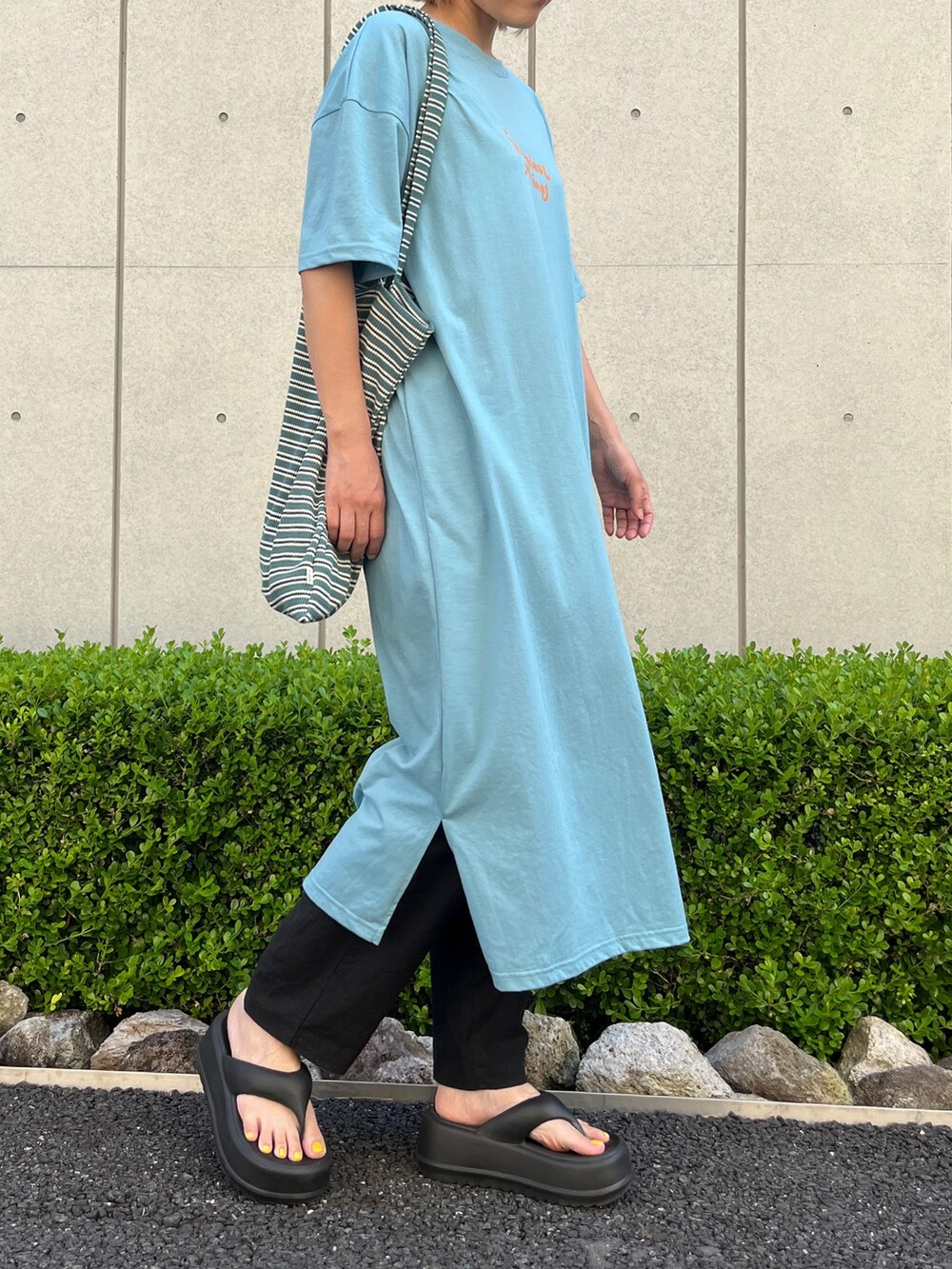 ブルー系のワンピース、ブラック系のサンダル、ブルー系のトートバッグを着用したレディースの夏コーディネートの3枚目の写真