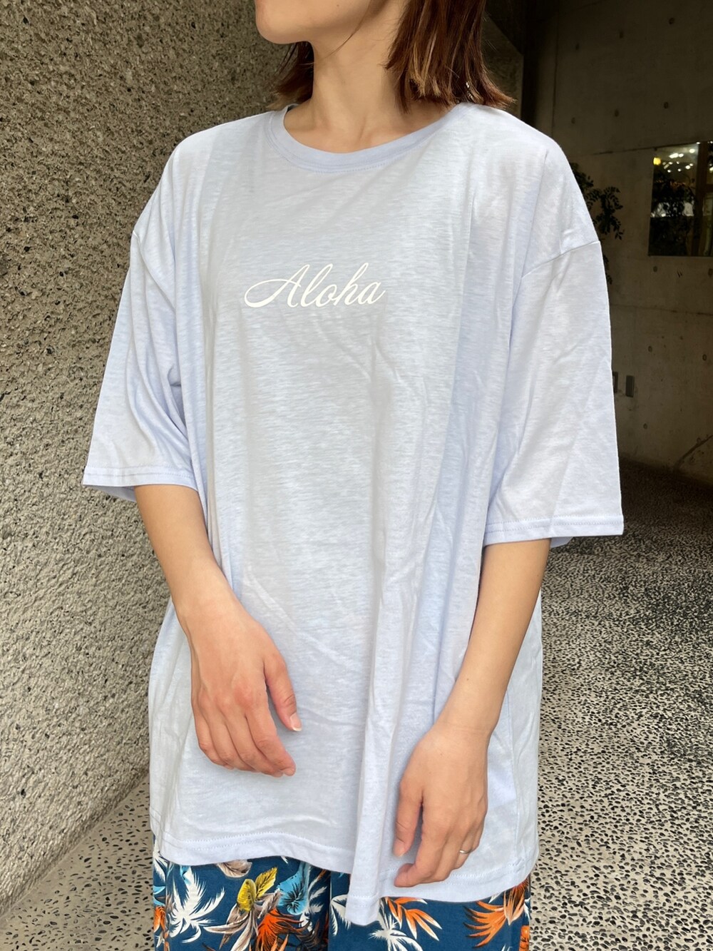 ブルー系のTシャツ/カットソー、ブラック系のスニーカー、ベージュ系のトートバッグを着用したレディースの春コーディネートの4枚目の写真