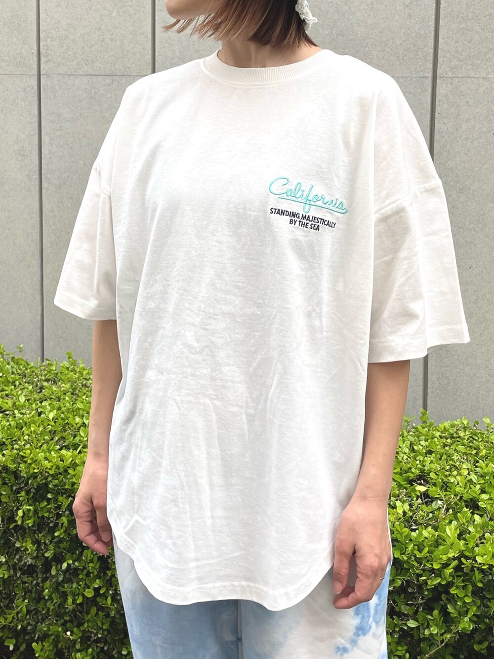 ホワイト系のTシャツ/カットソー、ホワイト系のスニーカー、ブルー系のハットを着用したレディースの春コーディネートの5枚目の写真