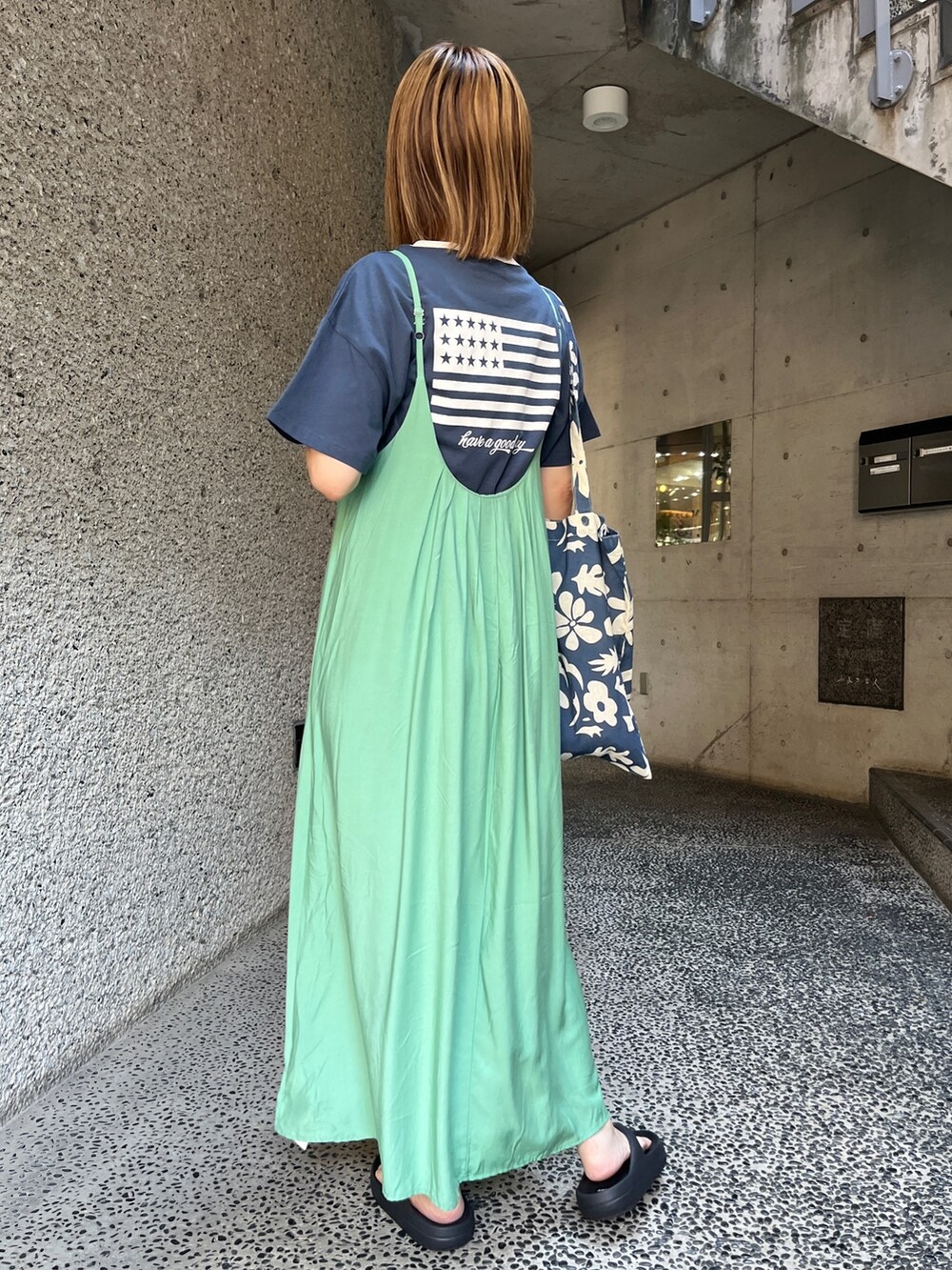グリーン系のワンピース、ブルー系のTシャツ/カットソー、ブラック系のサンダルを着用したレディースの夏コーディネートの2枚目の写真