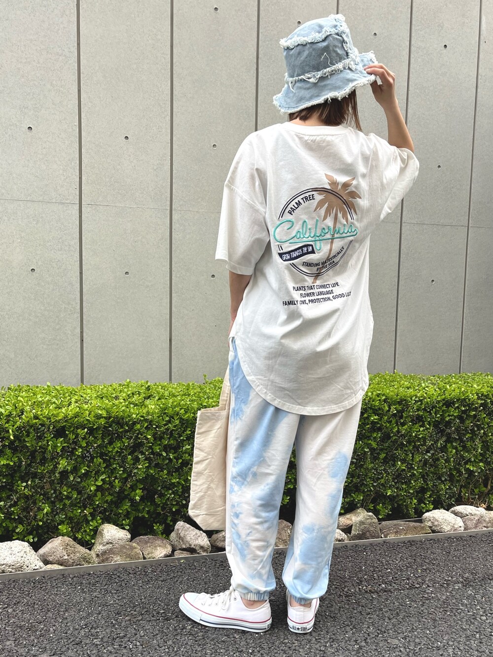 ホワイト系のTシャツ/カットソー、ホワイト系のスニーカー、ブルー系のハットを着用したレディースの春コーディネートの3枚目の写真