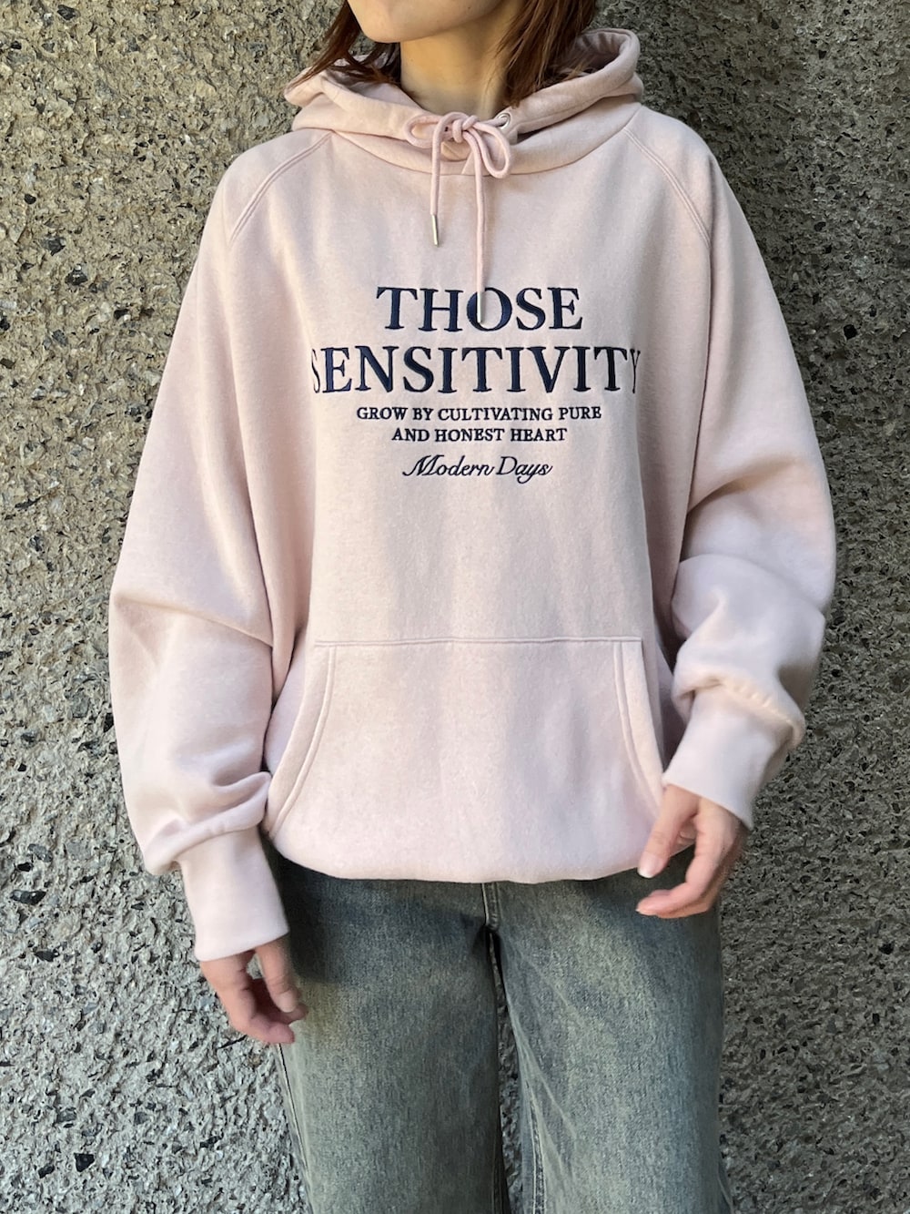 ブルー系のデニムパンツ、ピンク系のパーカー、ブラック系のショルダーバッグを着用したレディースの冬コーディネートの2枚目の写真