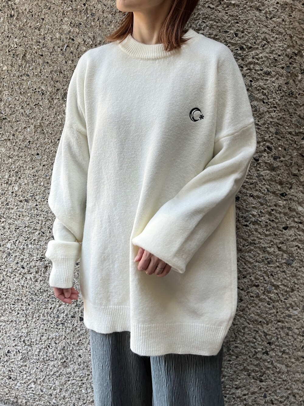 ホワイト系のニット/セーター、ホワイト系のショルダーバッグ、ブルー系のその他パンツを着用したレディースの冬コーディネートの2枚目の写真