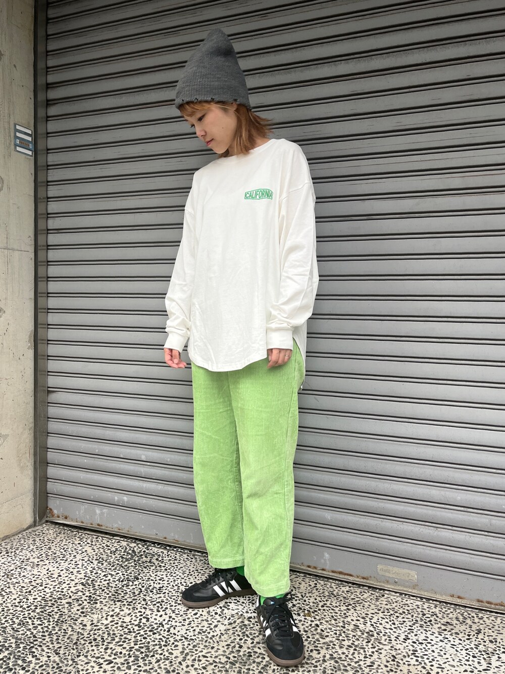 ホワイト系のTシャツ/カットソー、ブラック系のスニーカー、グレー系のニットキャップ/ビーニーを着用したレディースの秋コーディネートの2枚目の写真