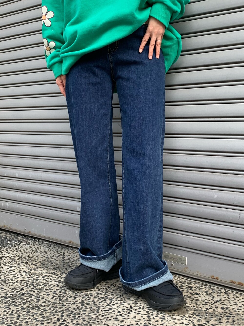 グリーン系のスウェット、ブルー系のデニムパンツ、ブラック系のシューズを着用したレディースの冬コーディネートの5枚目の写真