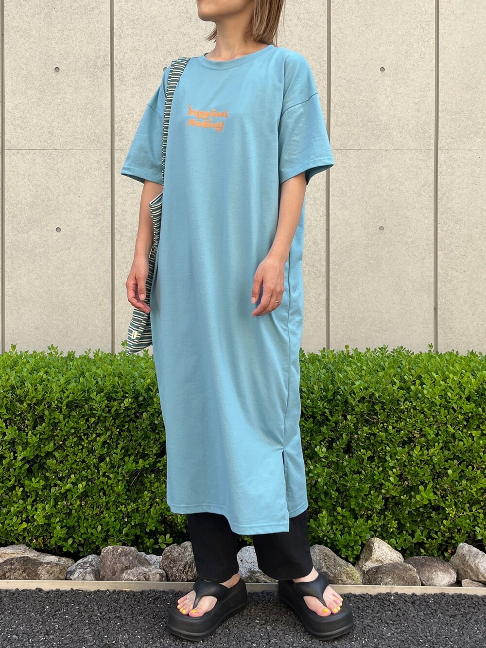 ブルー系のワンピース、ブラック系のサンダル、ブルー系のトートバッグを着用したレディースの夏コーディネートの2枚目の写真