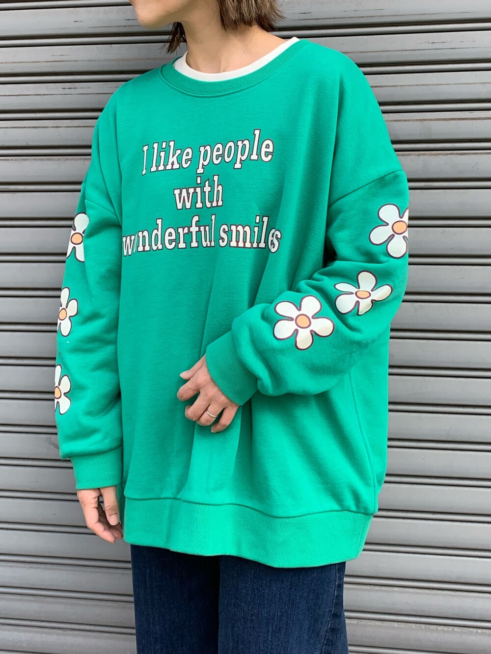 グリーン系のスウェット、ブルー系のデニムパンツ、ブラック系のシューズを着用したレディースの冬コーディネートの3枚目の写真