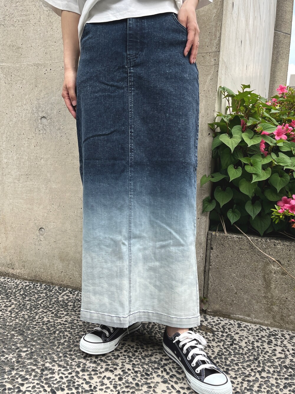 ホワイト系のTシャツ/カットソー、ブルー系のスカート、ブラック系のスニーカーを着用したレディースの春コーディネートの5枚目の写真