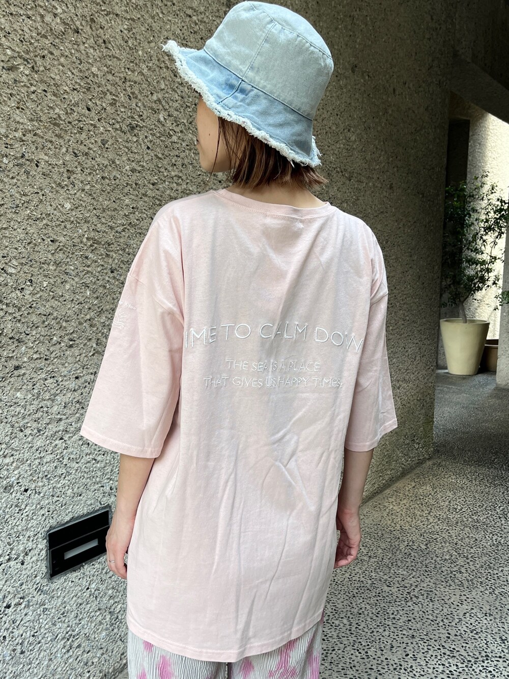 ピンク系のTシャツ/カットソー、グレー系のその他パンツ、ホワイト系のスニーカーを着用したレディースの春コーディネートの5枚目の写真
