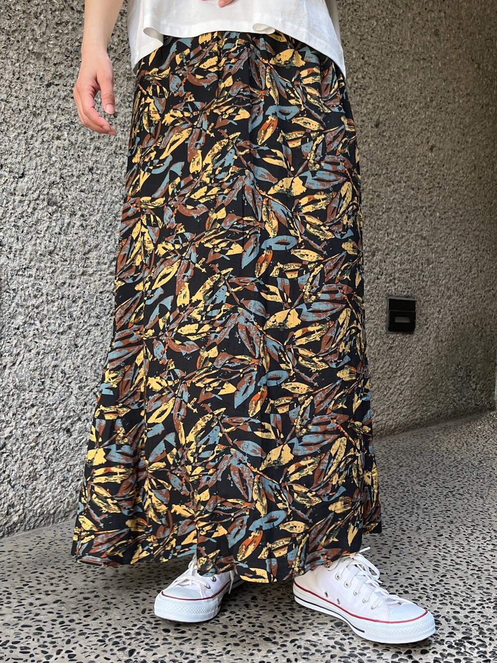 ホワイト系のTシャツ/カットソー、グレー系のスカート、ホワイト系のスニーカーを着用したレディースの春コーディネートの7枚目の写真