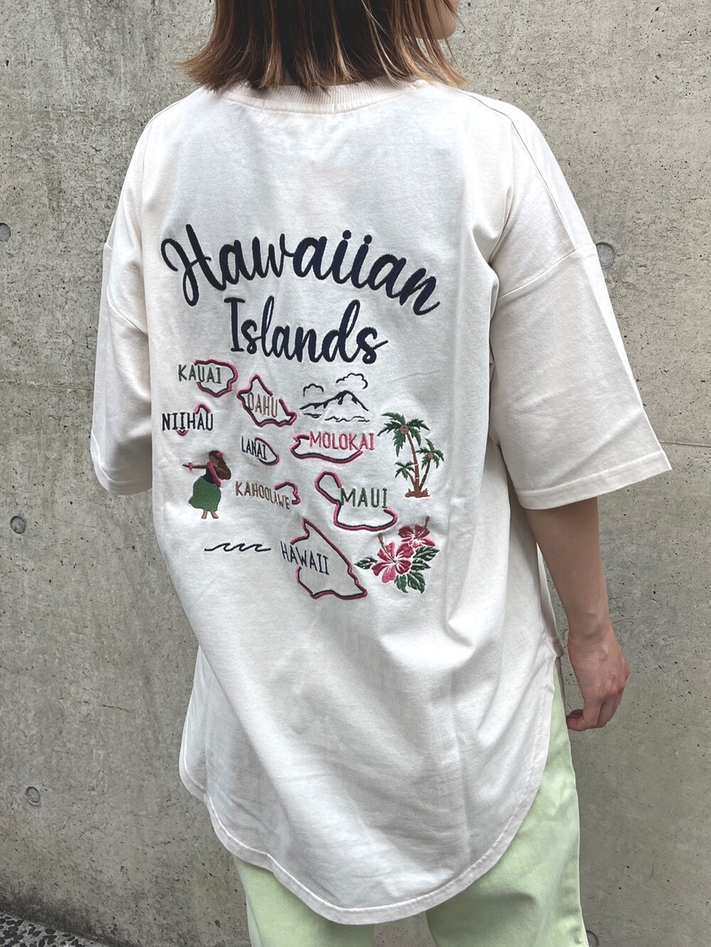 ベージュ系のスニーカー、グリーン系のデニムパンツ、ブルー系のトートバッグを着用したレディースの春コーディネートの4枚目の写真