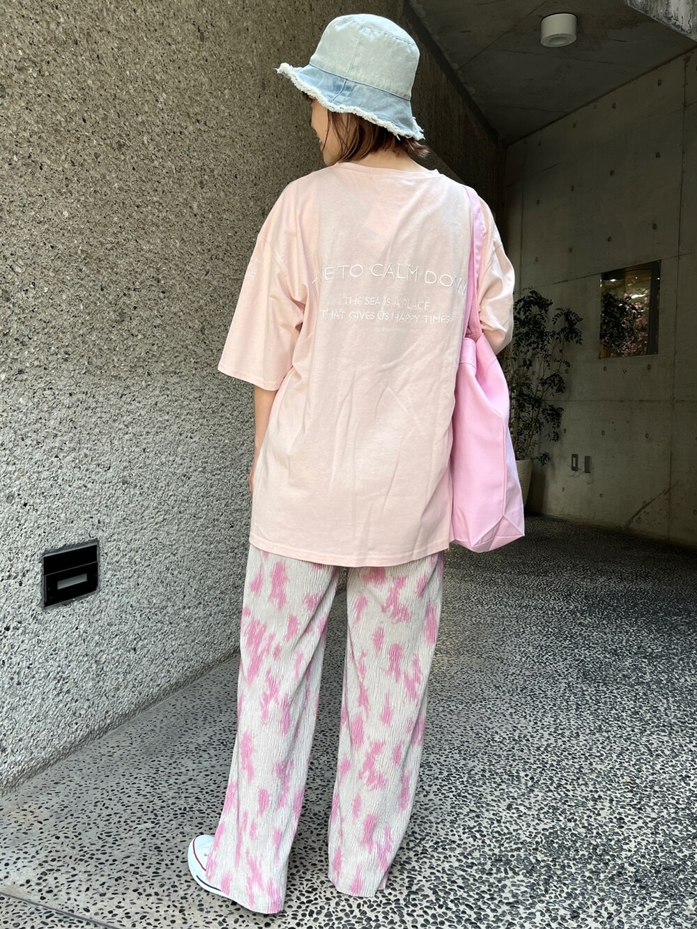ピンク系のTシャツ/カットソー、グレー系のその他パンツ、ホワイト系のスニーカーを着用したレディースの春コーディネートの3枚目の写真