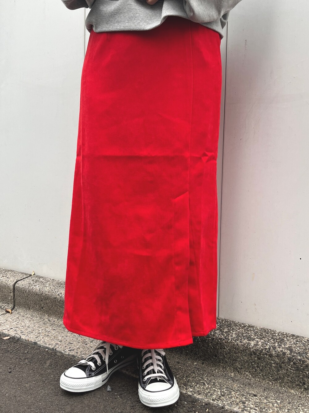 グレー系のスウェット、レッド系のスカート、ブラック系のスニーカーを着用したレディースの秋コーディネートの4枚目の写真