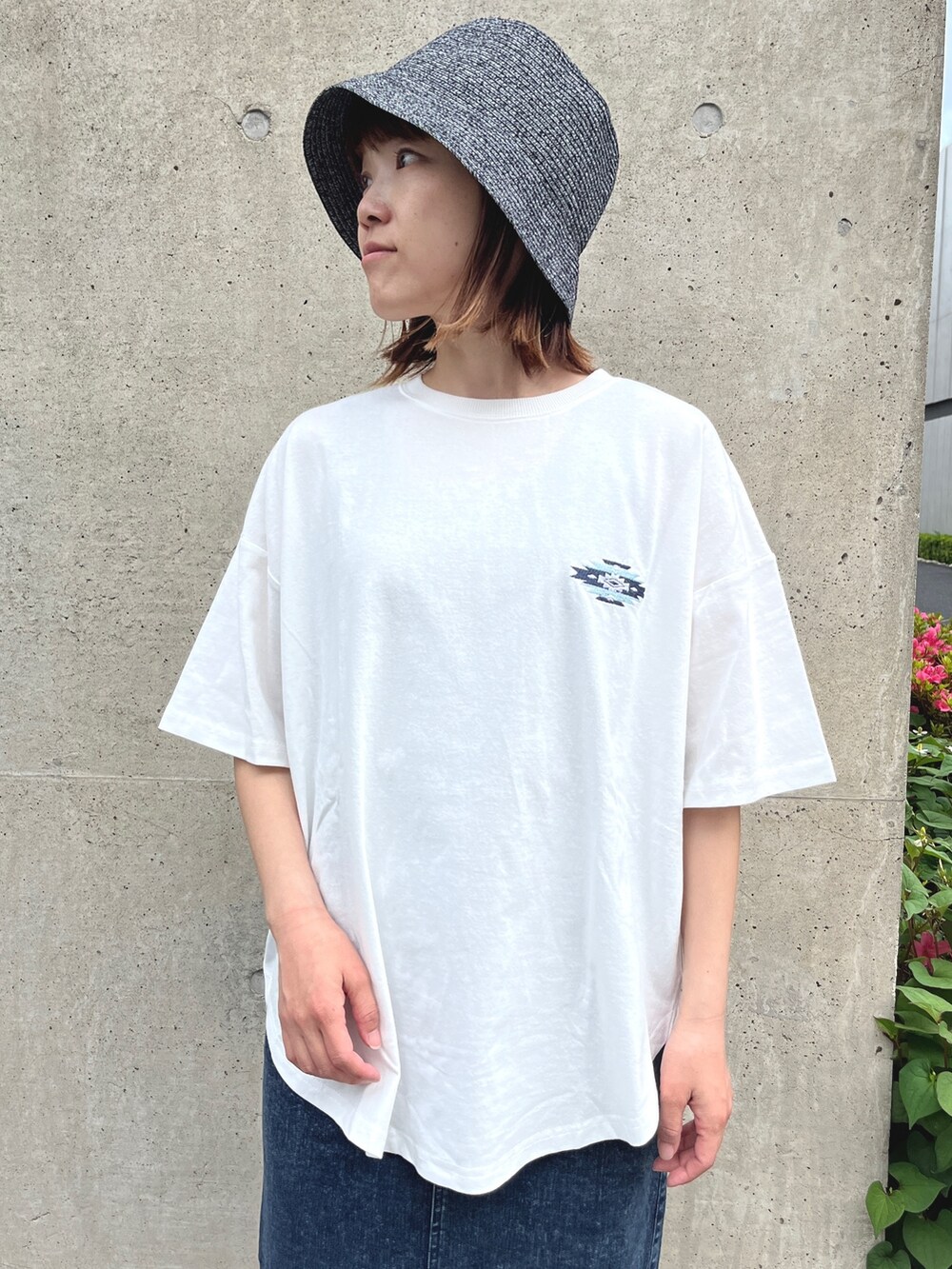ホワイト系のTシャツ/カットソー、ブルー系のスカート、ブラック系のスニーカーを着用したレディースの春コーディネートの3枚目の写真