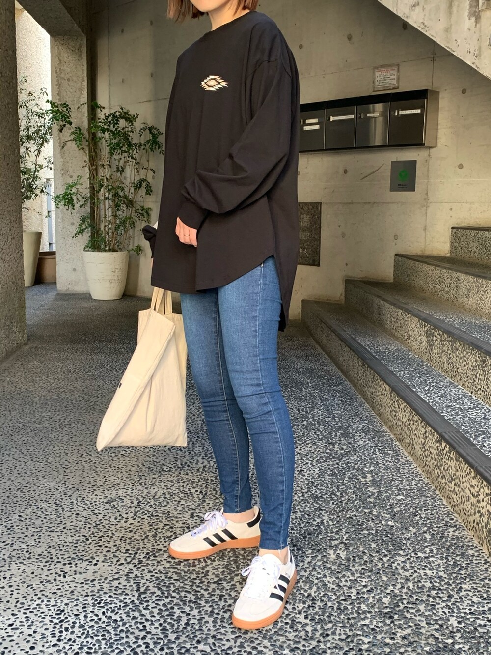 「オルテガ、スキニーデニム、スキニー、デニム、シンプルコーデ、スニーカー、adidas spezial、adidas、ロンT、パンツスタイル、トートバッグ、ラクチンコーデ、オルテガ柄、黒、バックプリント」｜「anap mimpiのオルテガ 刺繍 ラウンドヘム 長袖 ロンT（Tシャツ/カットソー、ブラック系）」を使った、Nakamuraさん（レディース・157cm）の春コーディネートの2枚目の写真