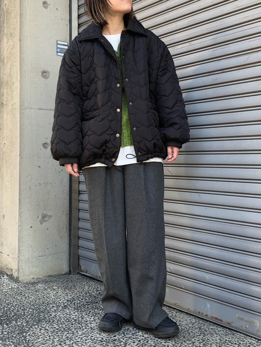 ブラック系のブルゾン、イエロー系のニット/セーター、ブラック系のシューズを着用したレディースの冬コーディネートの2枚目の写真