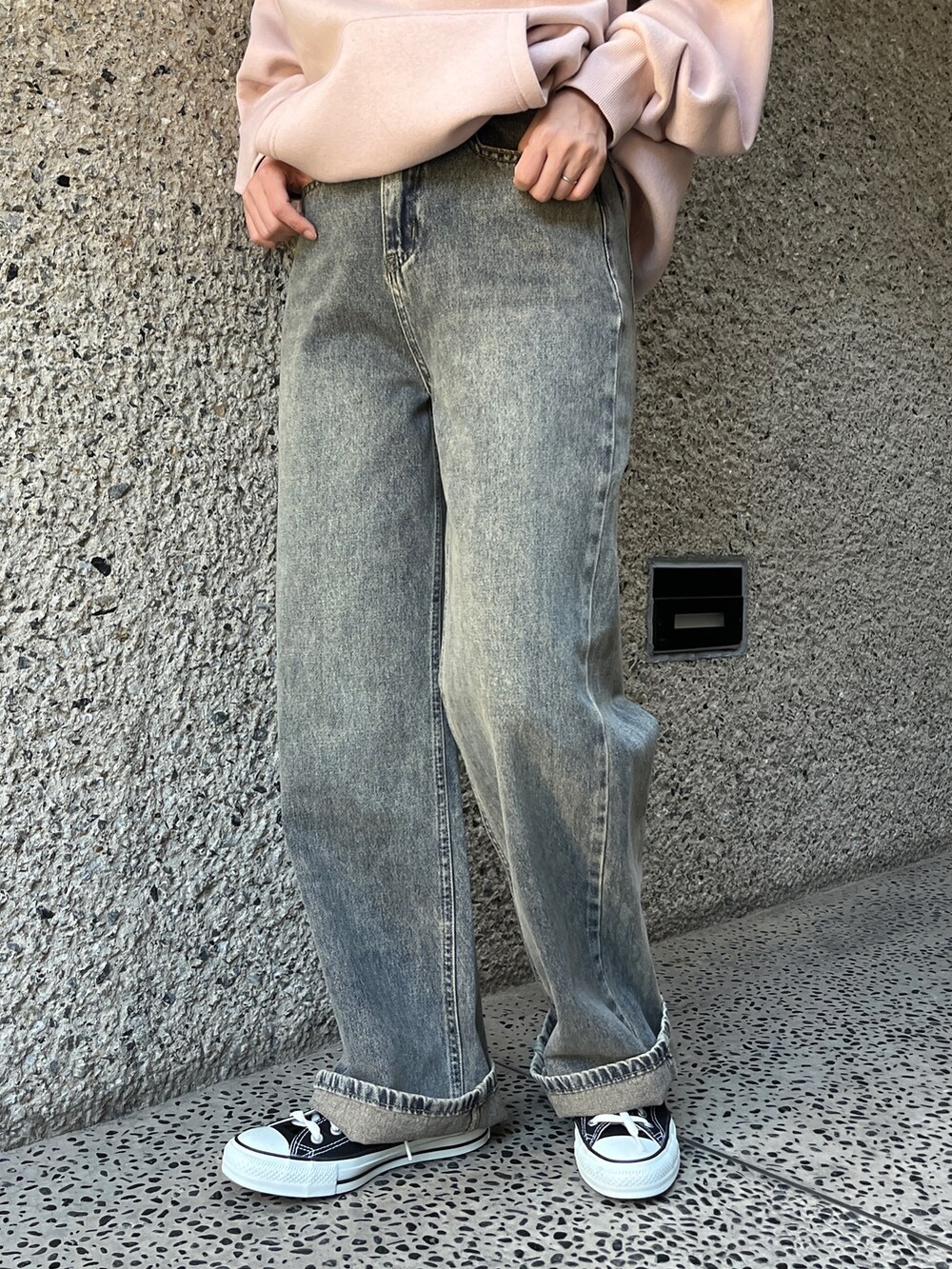 ブルー系のデニムパンツ、ピンク系のパーカー、ブラック系のショルダーバッグを着用したレディースの冬コーディネートの3枚目の写真