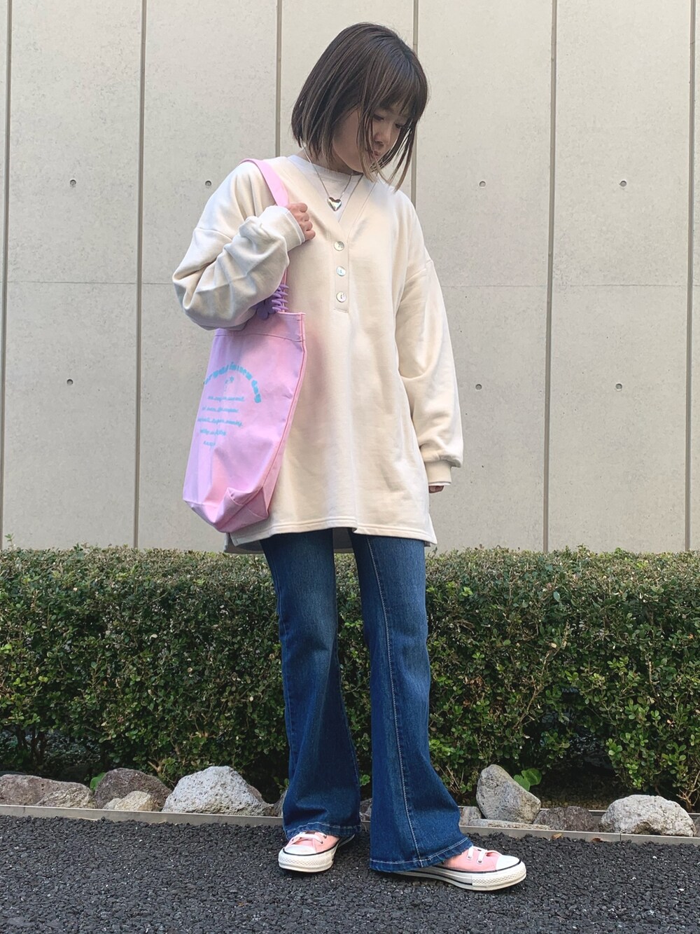 ベージュ系のワンピース、ピンク系のスニーカー、シルバー系のネックレスを着用したレディースの冬コーディネートの2枚目の写真