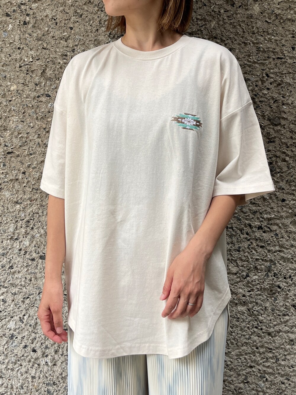 ホワイト系のTシャツ/カットソー、レッド系のパンツ、ベージュ系のトートバッグを着用したレディースの夏コーディネートの5枚目の写真