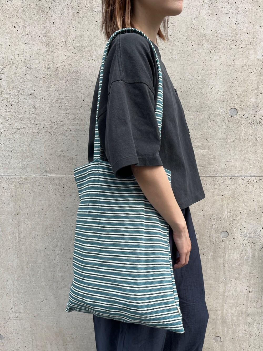 ブラック系のTシャツ/カットソー、ブルー系のその他パンツ、ベージュ系のサンダルを着用したレディースの春コーディネートの4枚目の写真