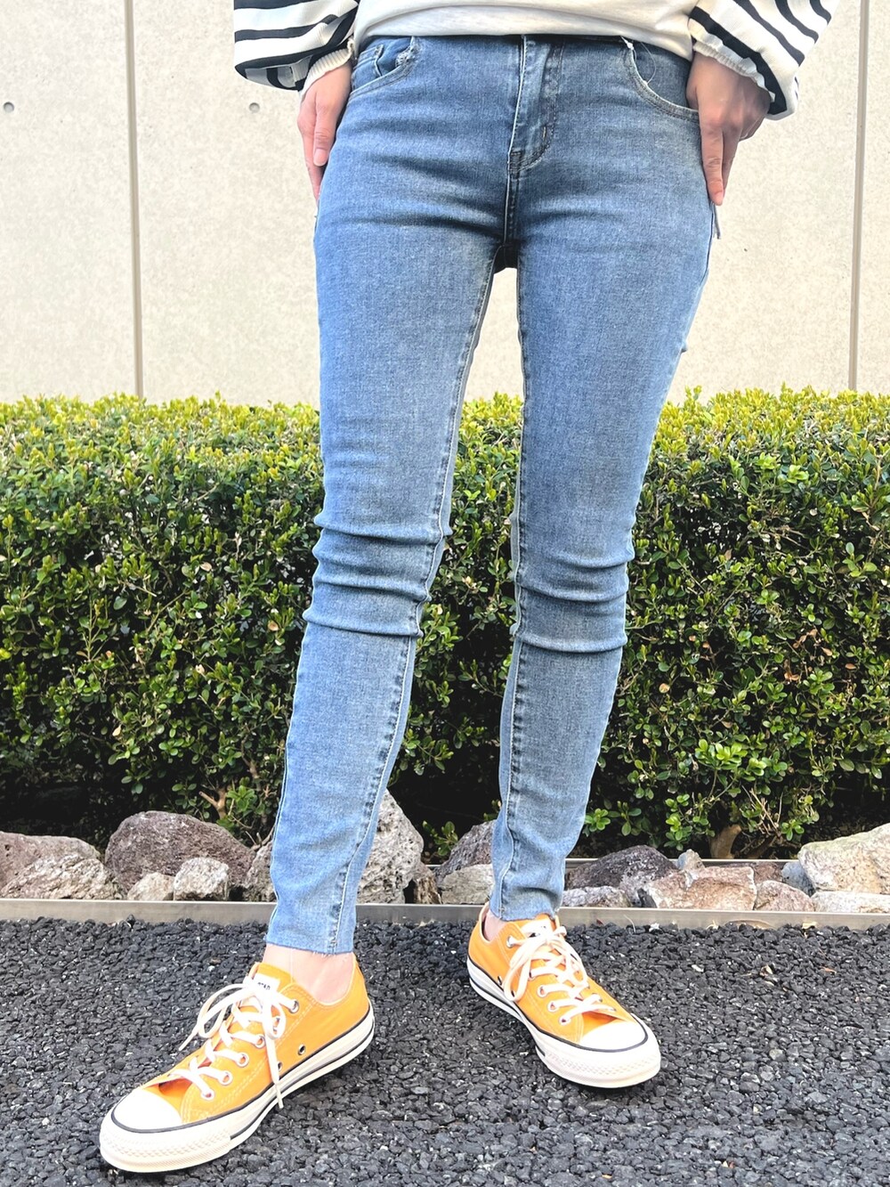 ホワイト系のニット/セーター、ブルー系のデニムパンツを着用したレディースの春コーディネートの5枚目の写真