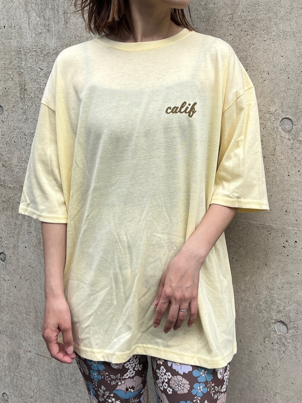 イエロー系のTシャツ/カットソー、ベージュ系のトートバッグ、ベージュ系のサンダルを着用したレディースの夏コーディネートの4枚目の写真